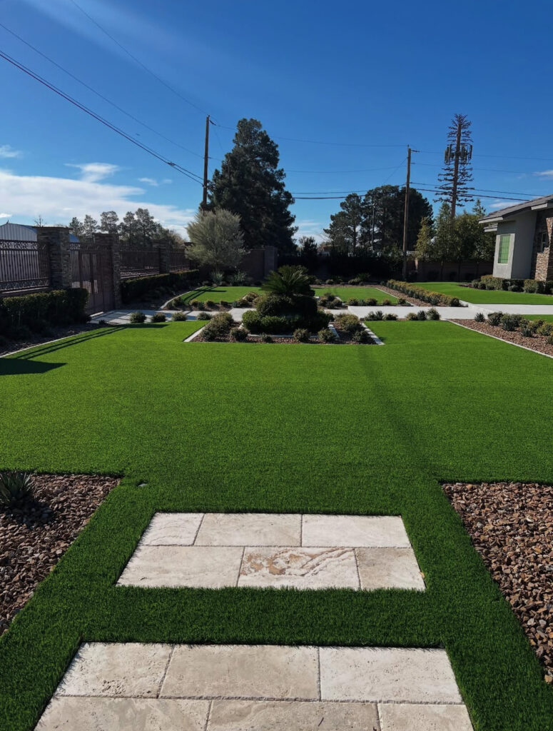 Lush green lawn with stone pathways and landscaped borders. A serene outdoor space, ideal for recreational activities, is shown under a clear blue sky.