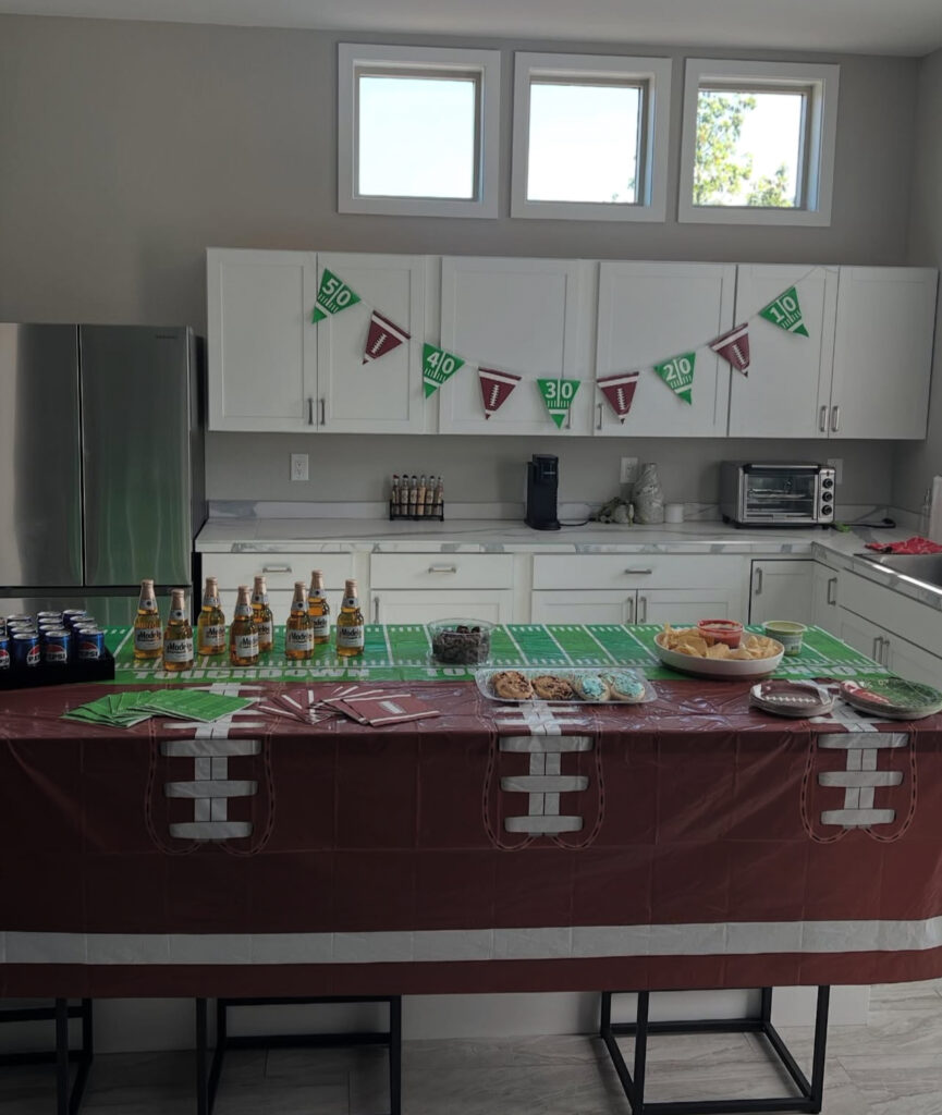 Football-themed party setup with snacks, drinks, and decorations, showcasing a festive kitchen space ready for game day celebrations.